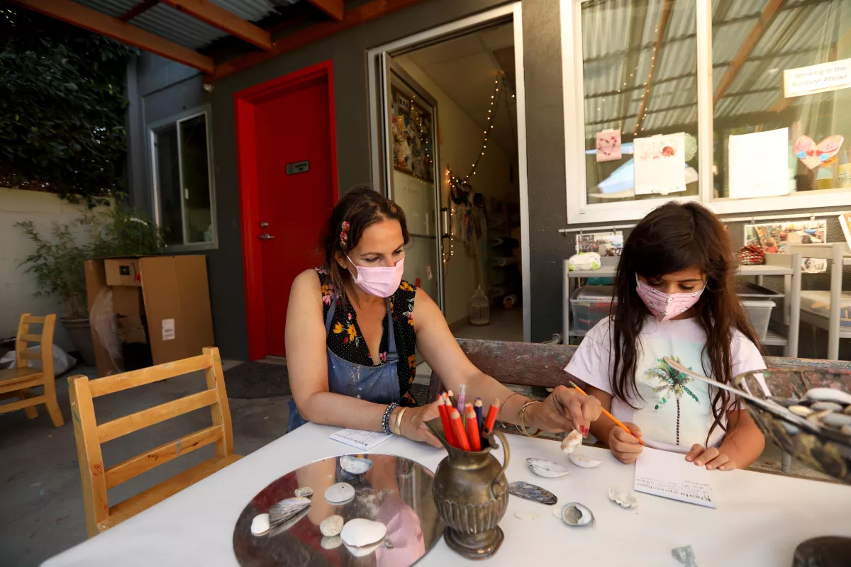 Teacher Jessy Morales, left, works with first grade student Ayza, at Kigala Preschool in Santa Monica.